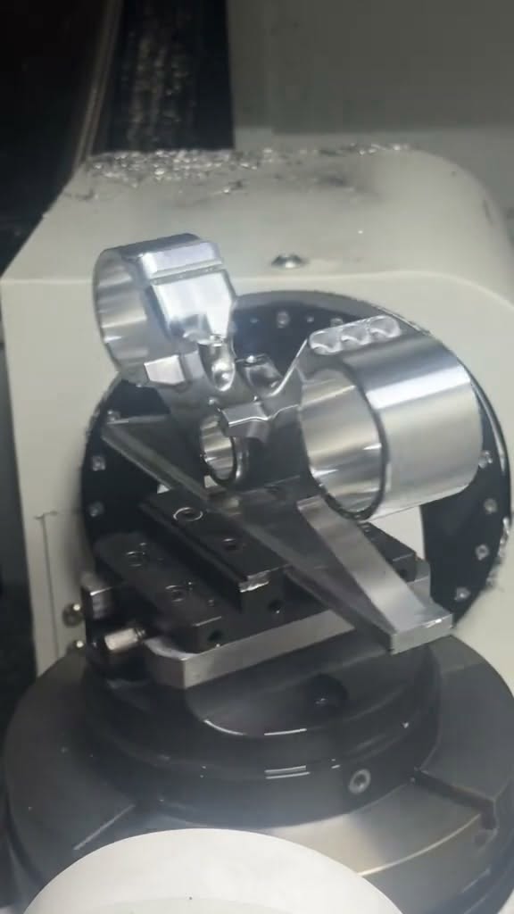 Frame from the Reel showing complex aluminum components being CNC machined on an indexed fixture